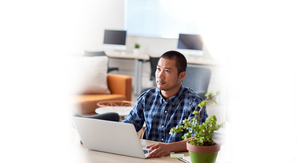 QBE Leadersip webinar series - psychology of human behaviour - man working at home on his laptop